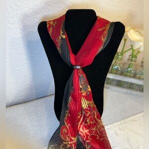 Red, black, and gold silk scarf with floral, filagree and vase motif. 53” x 10”